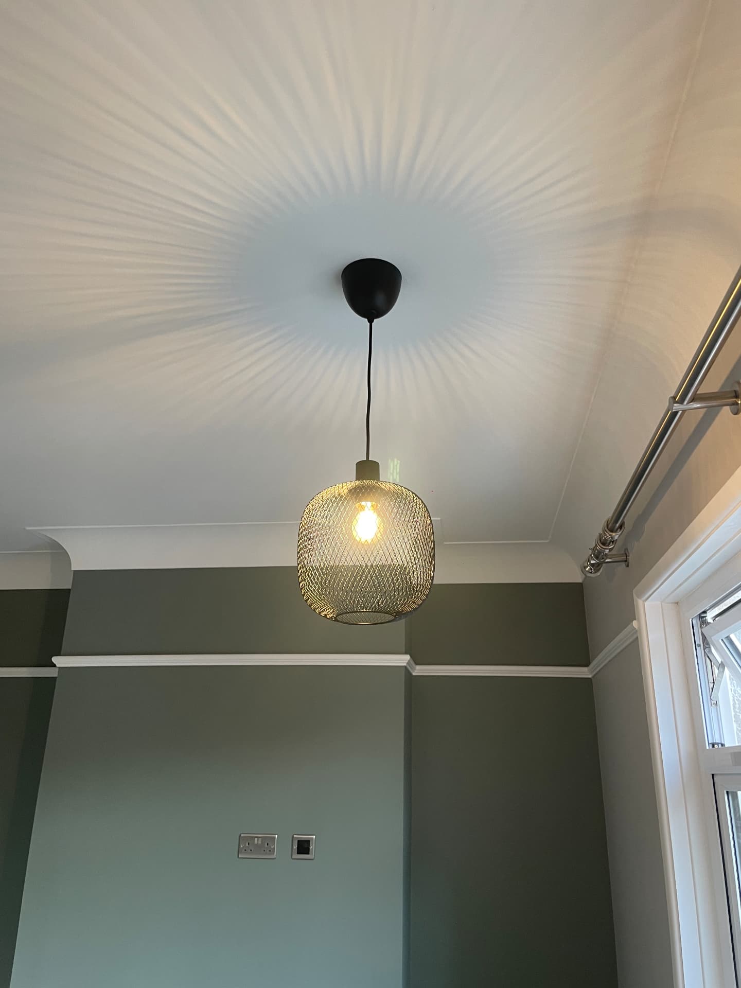 Brass mesh pendant light installed in a living room