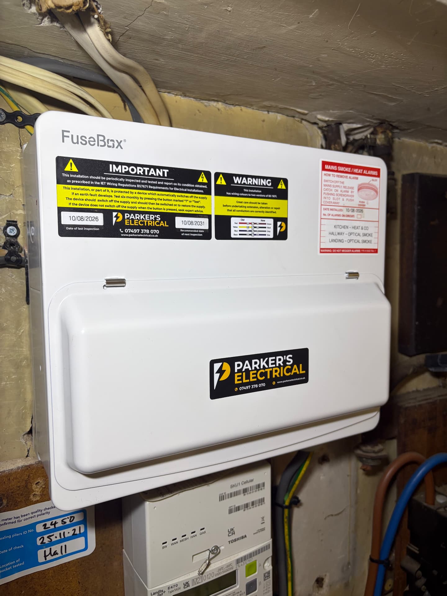 New FuseBox consumer unit installed in a hallway with inspection dates and alarm circuit labels