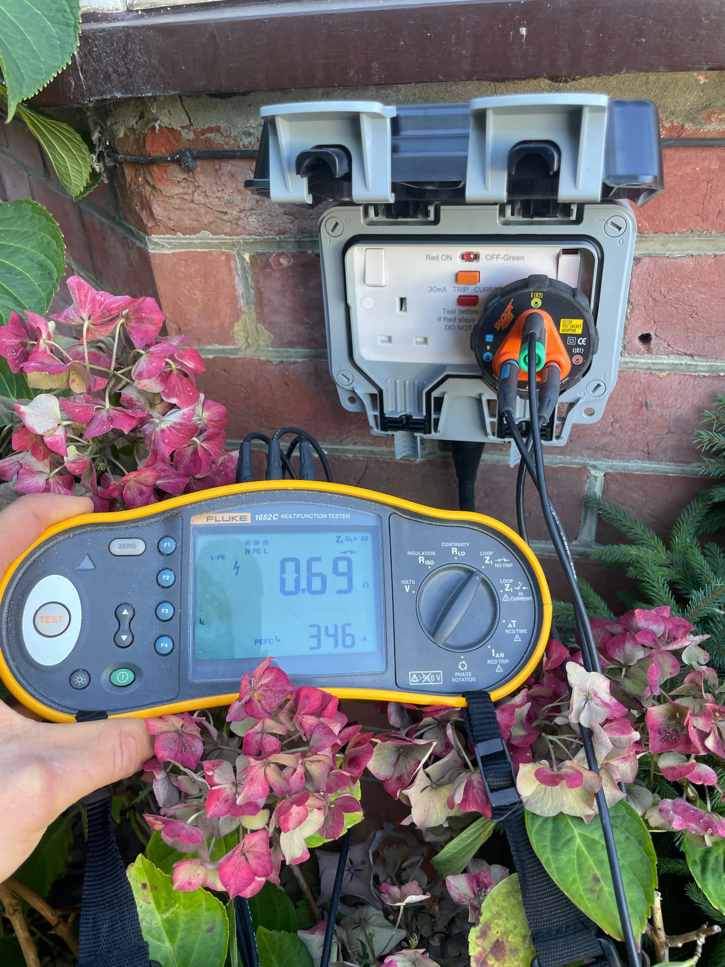 Weatherproof RCD outdoor socket being tested with a multifunction tester