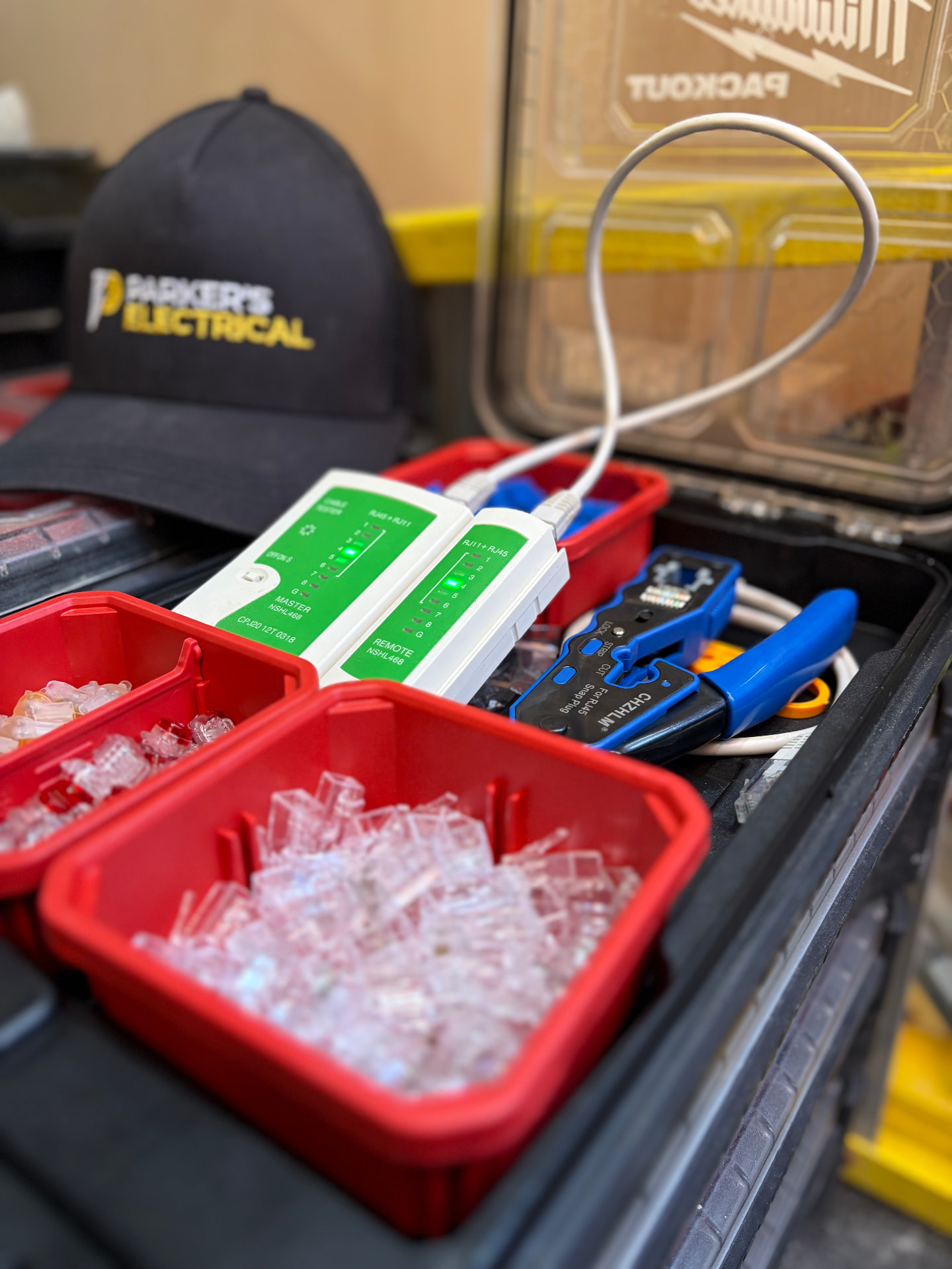 Cat6 data cabling being tested with an RJ45 cable tester alongside crimp tool and connectors
