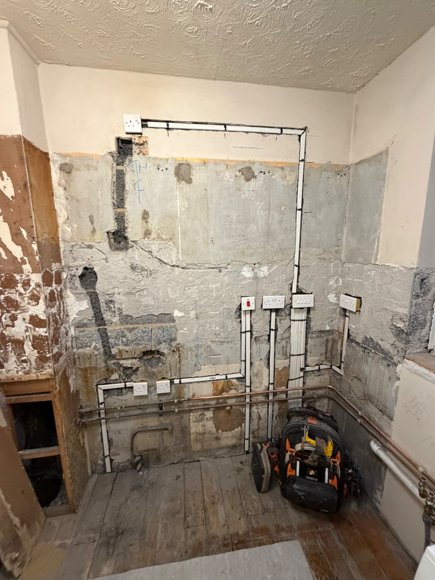 First-fix rewire cabling run around a stripped-back room
