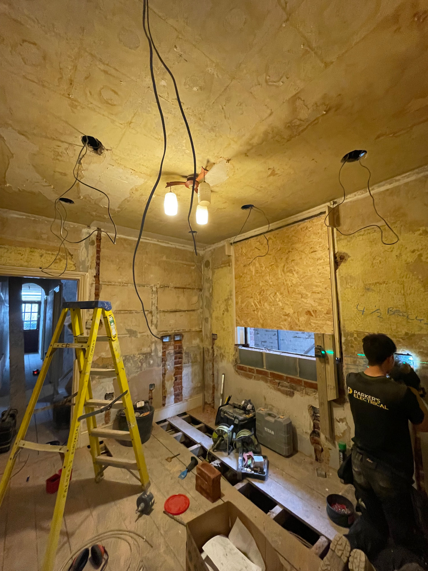 Parker’s Electrical electrician rewiring a stripped-back Southampton room with new lighting drops