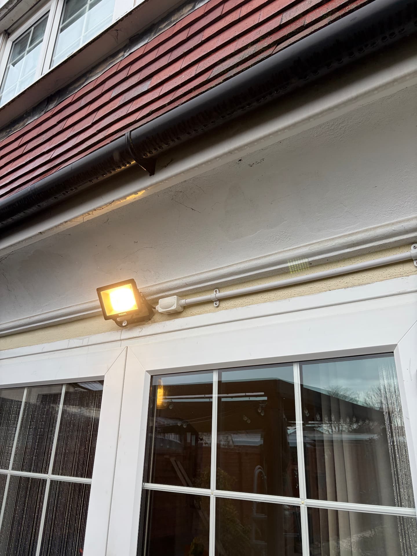 External LED floodlight installed above patio doors