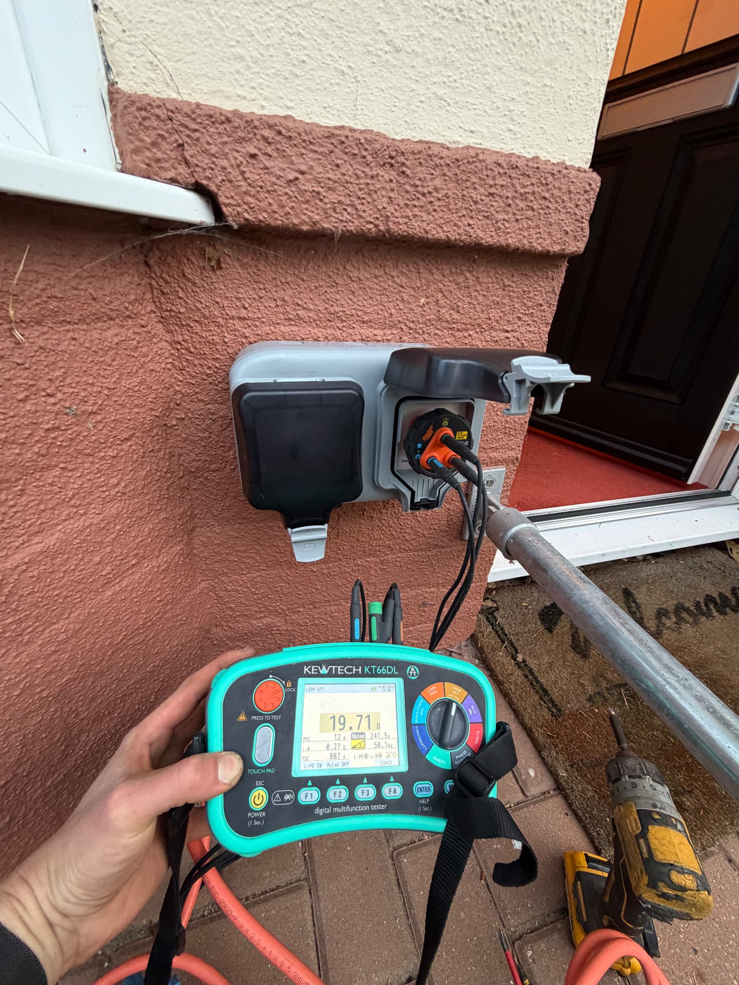 Weatherproof external socket tested beside a front porch
