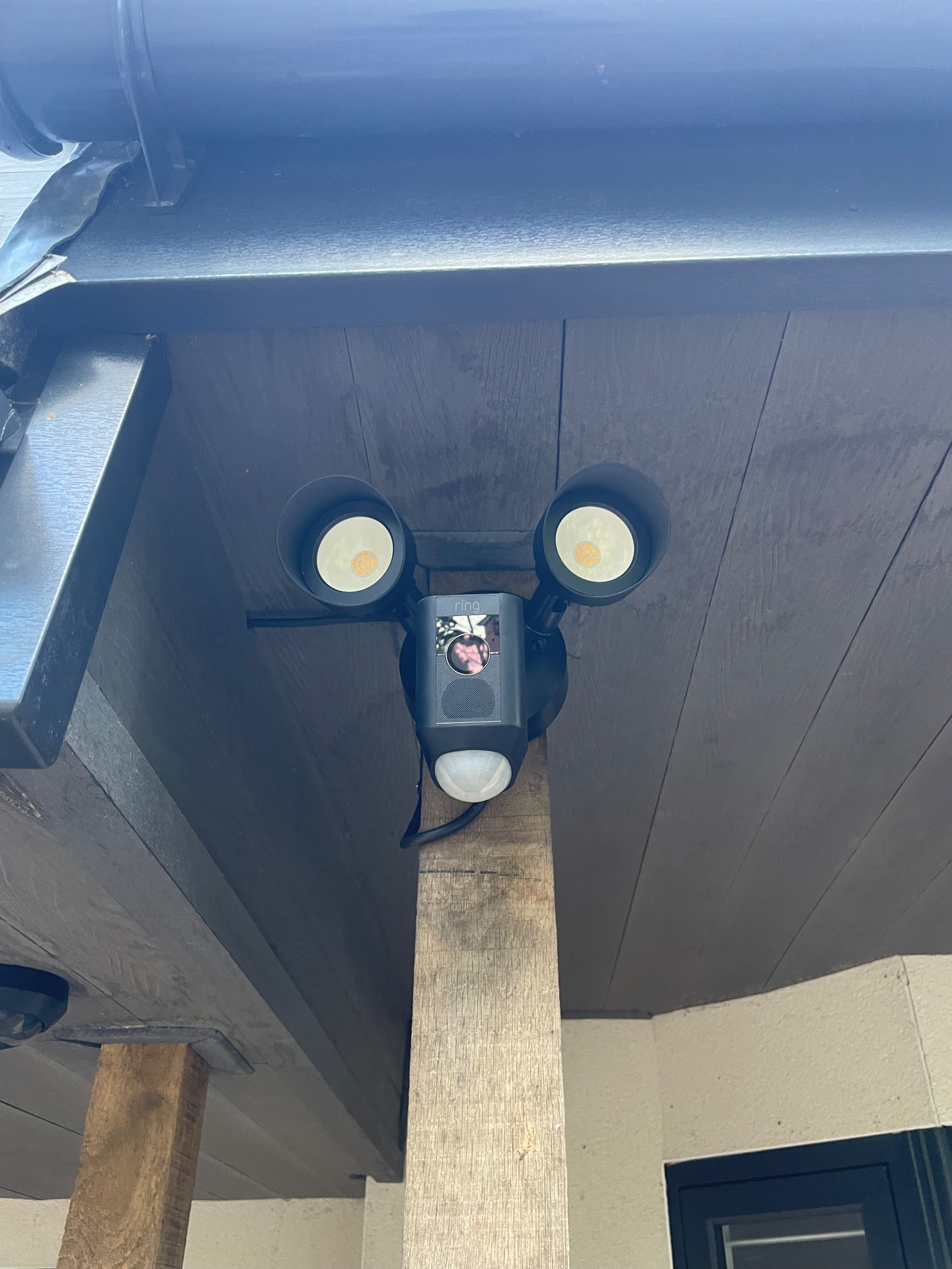 Ring floodlight camera installed under a covered porch canopy