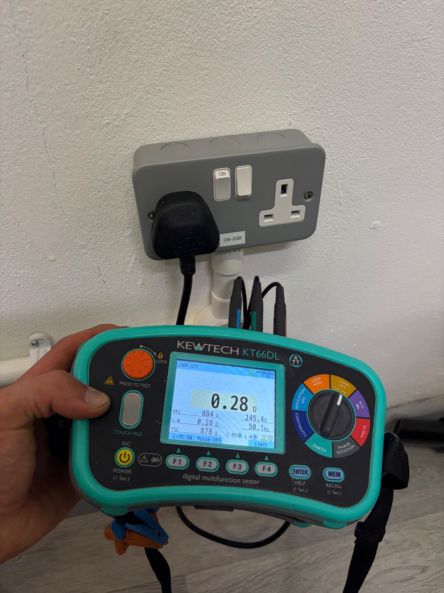 Loop impedance test on a labelled metal-clad socket during an electrical inspection