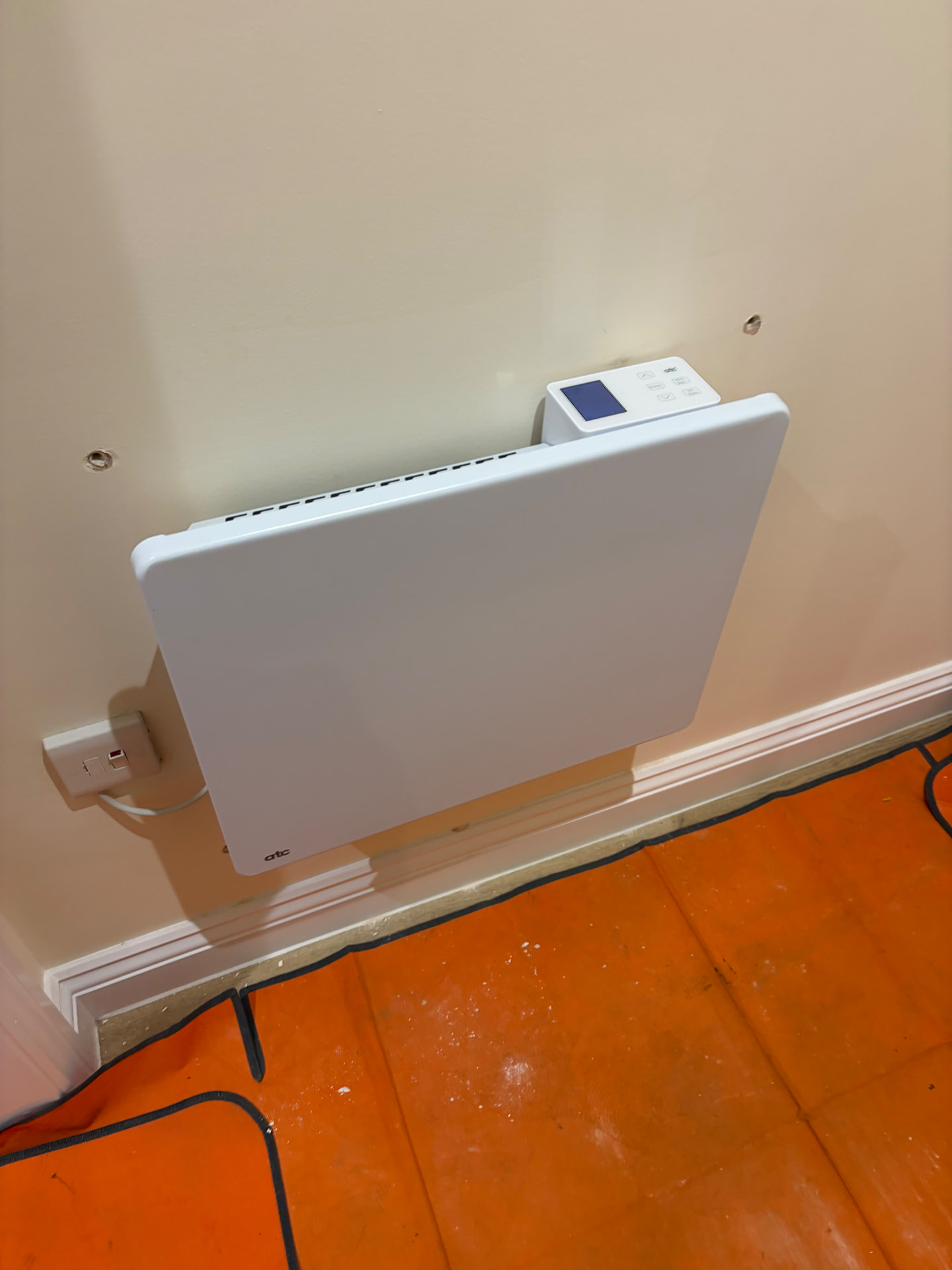 Wall-mounted electric panel heater with digital controls installed on a dedicated supply