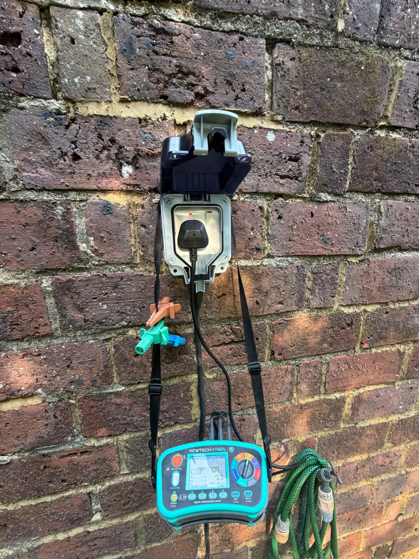 New outdoor socket installed on a brick wall and tested on completion
