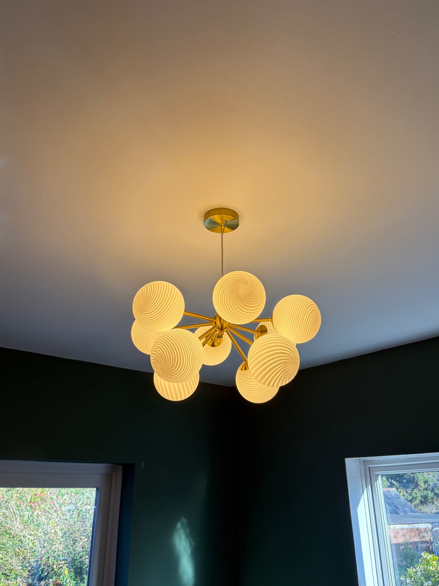 Brass multi-globe chandelier installed in a dining room