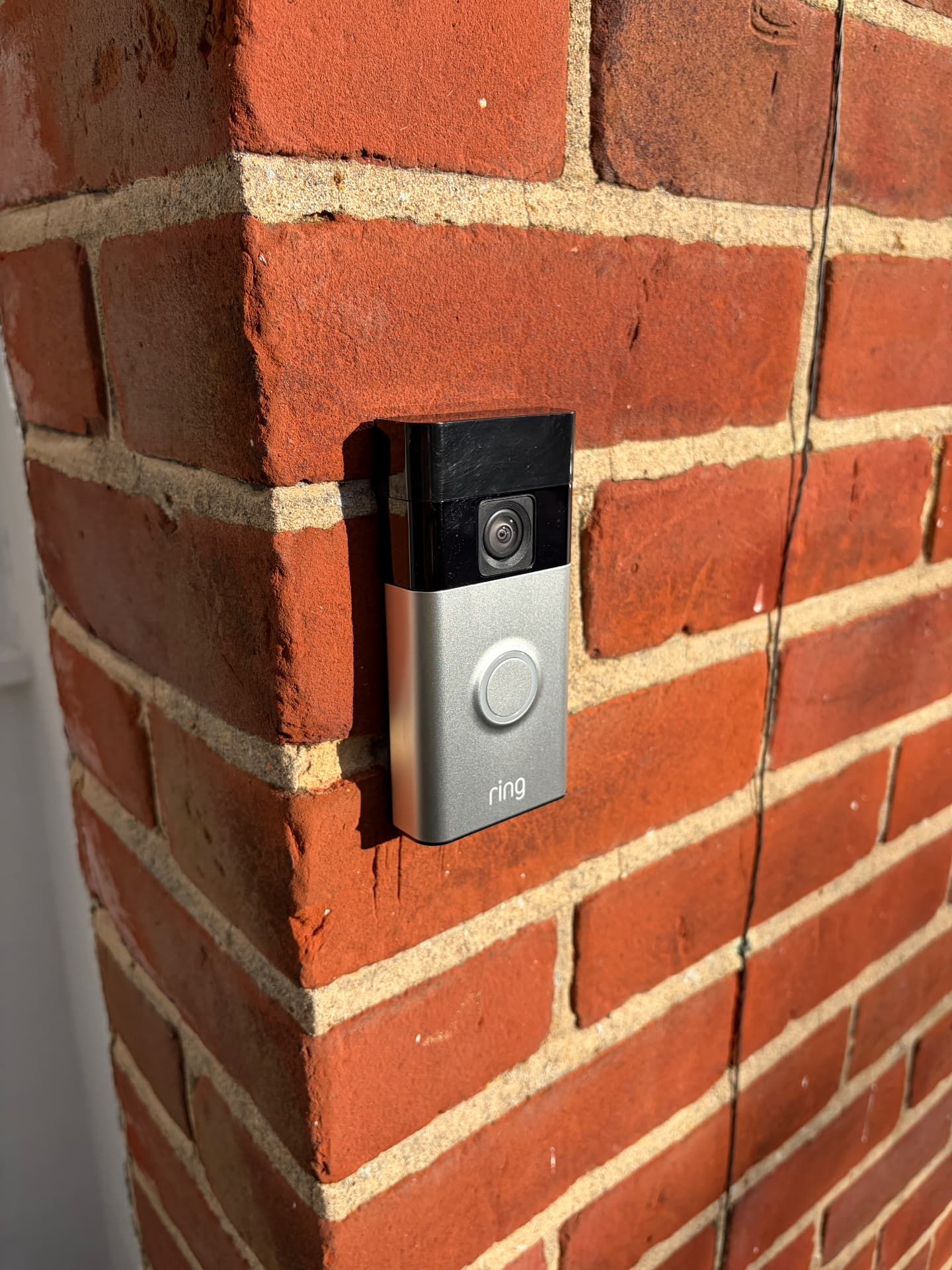 Ring video doorbell hardwired onto a brick porch pillar