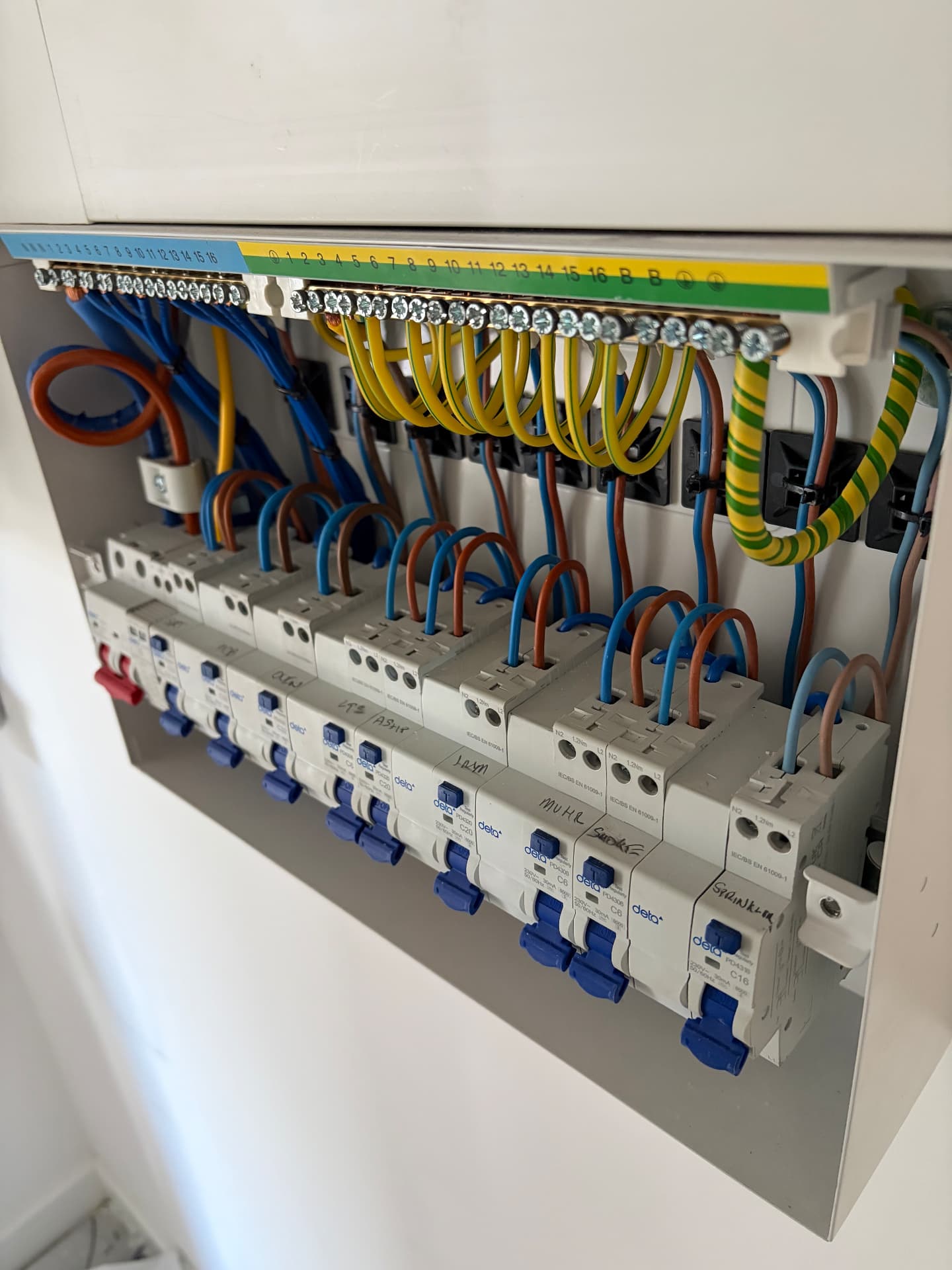 Neatly wired consumer unit with RCBOs and labelled circuits inside the enclosure