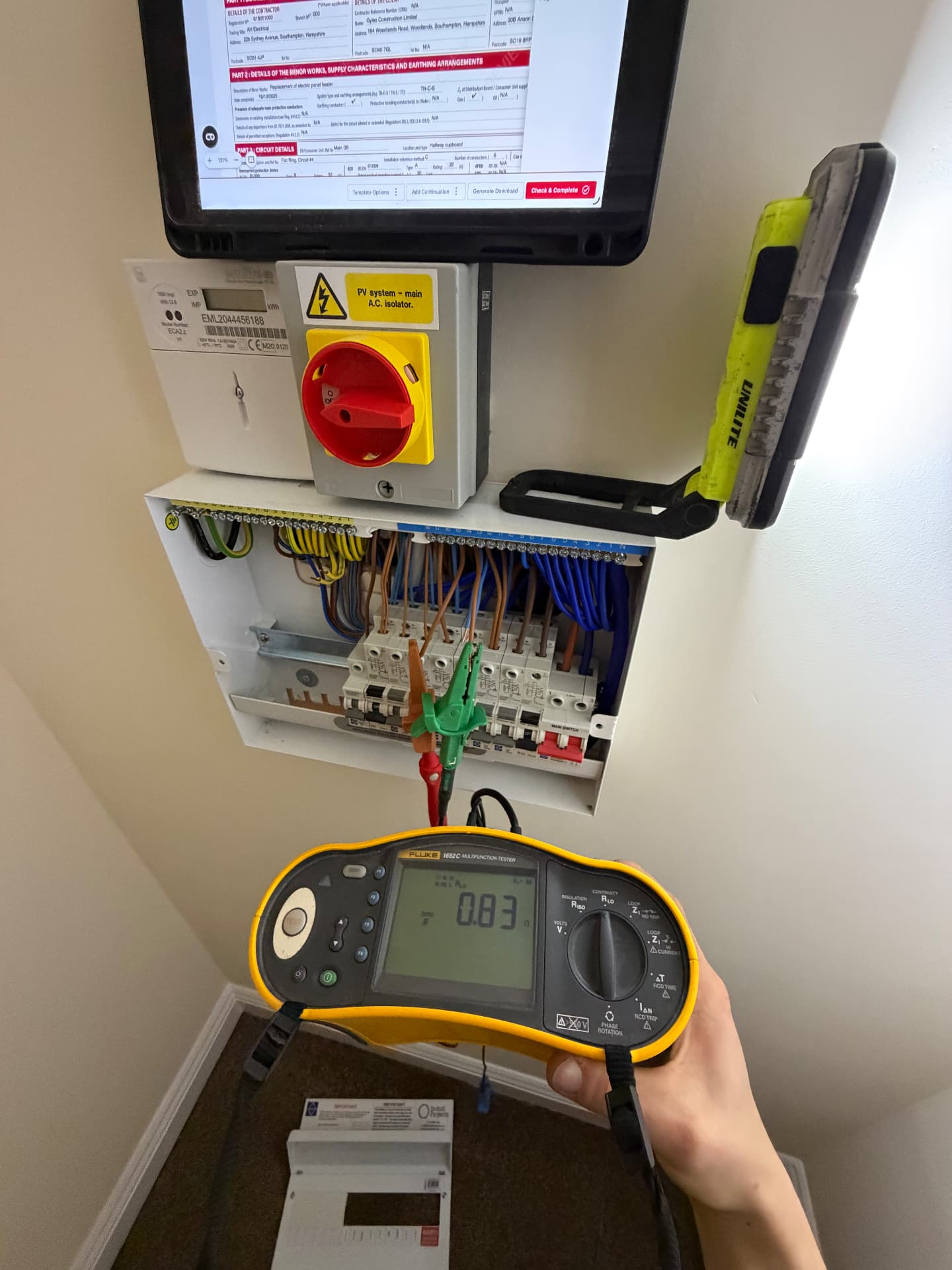 Earth loop impedance test at a consumer unit while completing the certificate on site